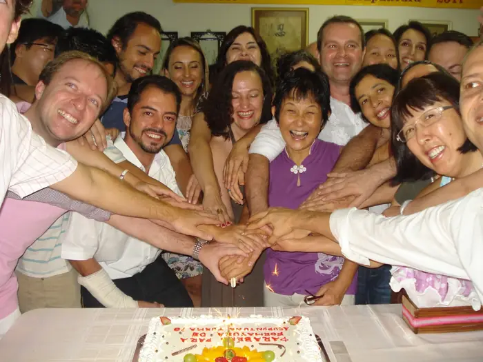 Mãos unidas em confraternização de turma de formação em Medicina Chinesa