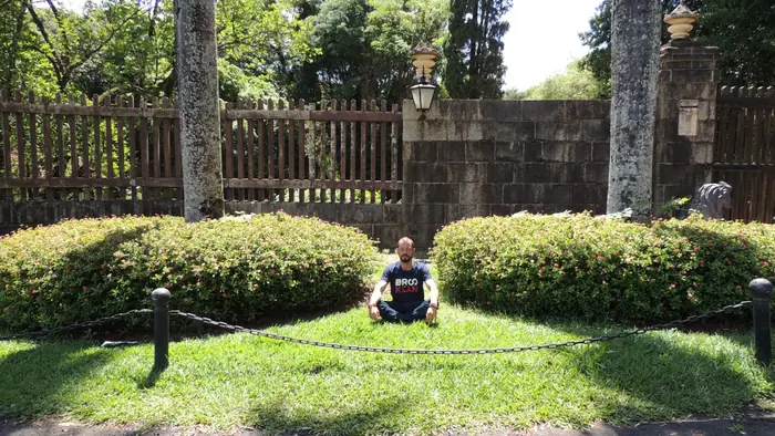 Jardim onde Caio Gracco pratica meditação, com muro de pedra e vegetação